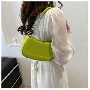 Fashionable neon green crescent bag with silver chain strap shown on a model