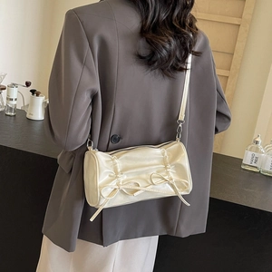 Sac baguette plissé blanc crème chic avec nœud porté comme un sac bandoulière élégant