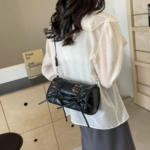 Sac à bandoulière cylindrique noir plissé avec nœuds et finition en similicuir brillant