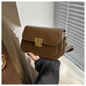 Close-up of dark brown PU leather crossbody bag featuring gold buckle and stitching details