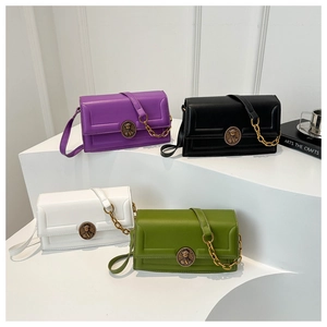 Detailed view of four small rectangular flap bags in purple, black, white, and green