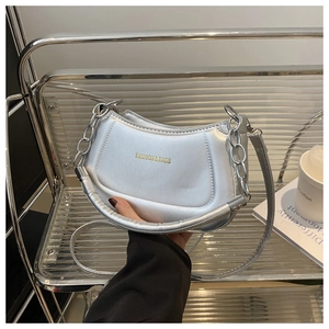 Detailed shot of silver crescent moon crossbody bag with chunky metal chain and gold logo
