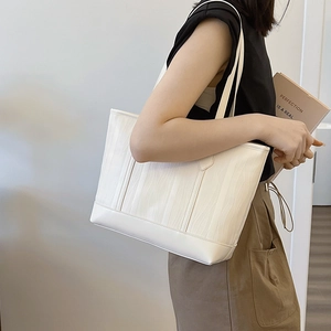 Minimalist white tote bag with textured leather shown on model for daily commuting