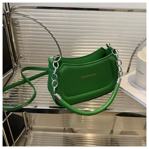 Macro detail of a lime green crescent bag with silver chain and gold logo text