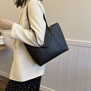 Black large-capacity tote bag with wavy embossed texture and slender double straps