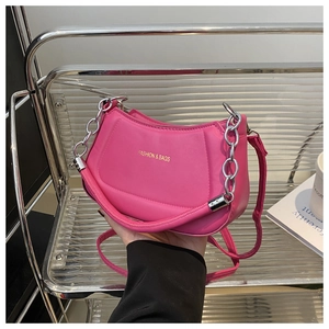 Detail of rose pink crescent bag with fashion text, silver chain and crossbody strap