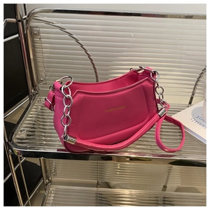 Detail of rose pink crescent bag showing metal chain, PU leather texture and slogan