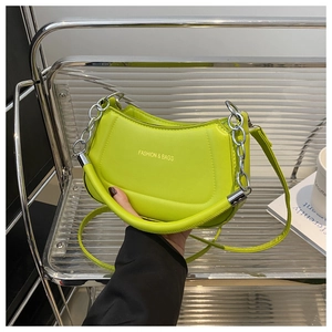 Detail of lime green crescent shoulder bag with metal chain and Fashion text
