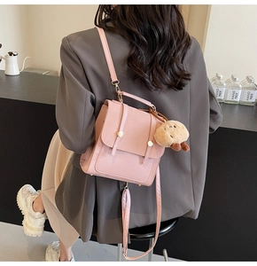 Pink PU leather backpack on grey blazer with a cute brown plush bear charm detail
