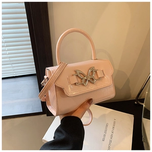 Detailed close-up of a pink patent leather mini bag with a silver butterfly buckle