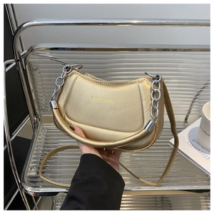 Champagne gold crescent bag detail featuring silver chain handle and fashion text logo
