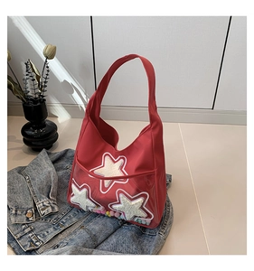 Détail du sac fourre-tout en nylon rouge avec poche PVC et boules de peluche colorées