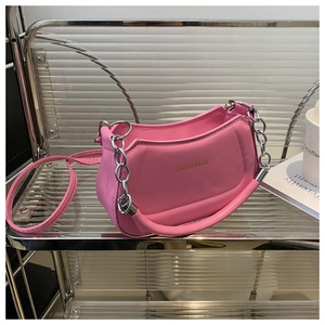 Close-up of pink crescent moon bag with metal chain handle and fashion text logo