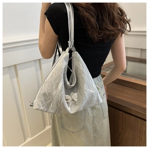 Sac fourre-tout argenté métallisé avec ornement papillon porté par un mannequin