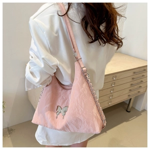 Sac à épaule plissé rose avec pendentif papillon argenté et détails de chaîne