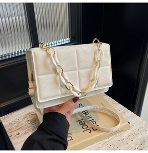 Détail du sac matelassé blanc à motif marbre avec chaîne dorée et en résine