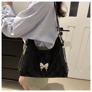 Sac sous le bras noir chic avec boucle papillon argentée et chaînes décoratives