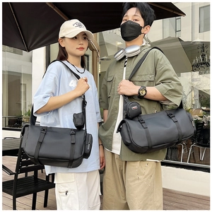 Close-up of black travel fitness bag with adjustable strap and small round pouch accessory