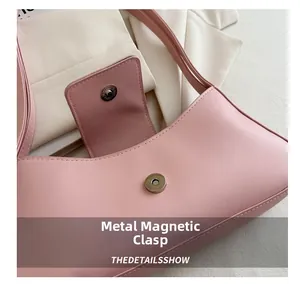 Detailed macro shot of the pink leather bag with a silver magnetic closure and neat stitching