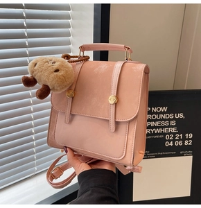 Detailed shot of pink mini backpack with golden buckle and brown plush charm