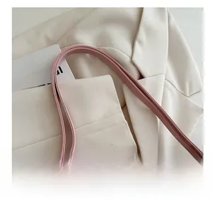 Close-up of pink leather handbag shoulder strap showing soft texture and neat stitching