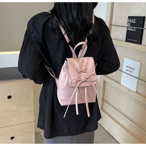 Close-up of the elegant pink bow detail and PU leather texture on the stylish backpack