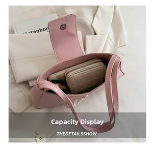 Pink bow shoulder bag interior capacity showing a wallet and cosmetics on a blazer