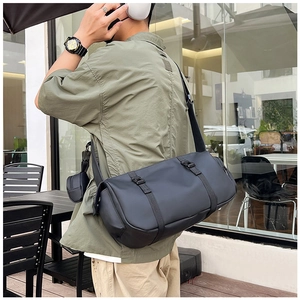 Detail view of a black waterproof cylinder messenger bag with functional buckle straps