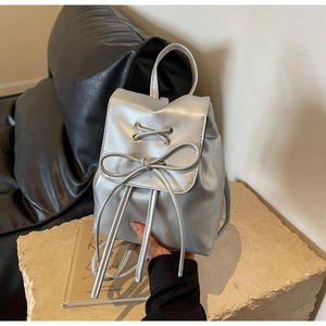 Detailed macro view of the silver mini backpack featuring a stylish bow knot and metallic finish