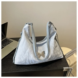 Vue détaillée du sac cabas plissé argenté avec boucle papillon en métal et chaîne