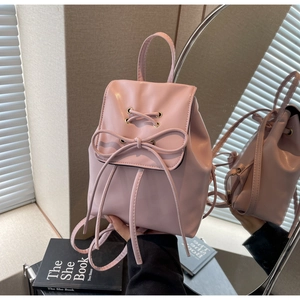 Detail view of pink PU leather mini backpack with bow decoration and drawstring