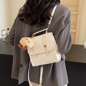 Vintage cream white backpack with dual strap design and a cute plush bear charm