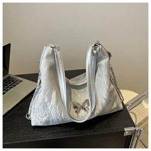 Détail du sac fourre-tout argenté plissé avec boucle papillon et bandoulière chaîne