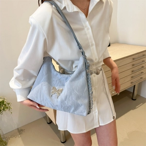 Grand sac cabas bleu clair avec texture plissée et accessoire papillon en métal argenté