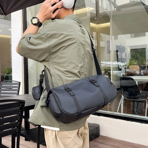 Water-resistant black cylindrical sports gym bag with small side pouch for men and women