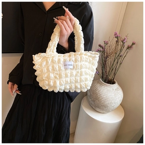 Close-up of white popcorn fabric lunch bag featuring the Love Fashion square logo tag