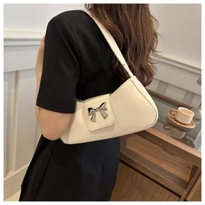 Detailed back view of a beige baguette bag with a silver metallic bow buckle accent