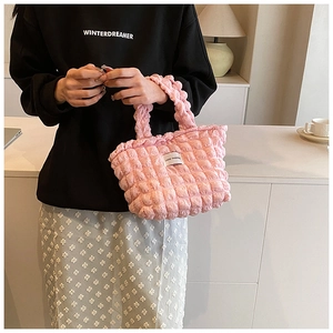 Detail of pink popcorn textured handbag with soft bubble pleated fabric and label