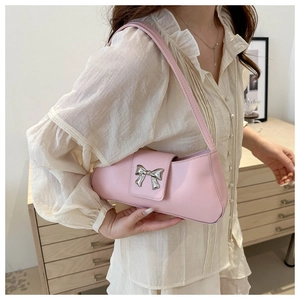 Detailed view of a pink leather underarm bag featuring a silver bow buckle decoration