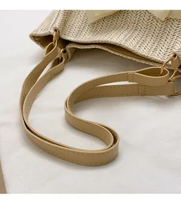 Détail du sac en paille avec tissage à chevrons et bandoulière en cuir beige clair
