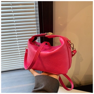 Détail du sac à main en cuir PU magenta avec motif lettres en relief élégant