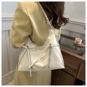 Detail view of cream PU leather tote bag featuring elegant bow ties and double zipper design