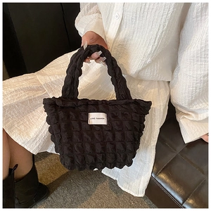 Detail of black bubble texture tote bag featuring a white LOVE FASHION woven label