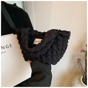 Detail of black quilted puffer lunch bag with bubble texture and LOVE FASHION woven label