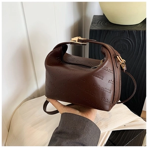 Détail du sac polochon cylindrique marron foncé avec motif Rich Rabbit en relief et doré