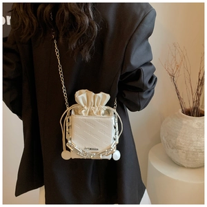 Detail view of white mini box bucket bag with rich rabbit embossing and metal chains