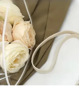 Vue détaillée de la bandoulière en cuir beige lisse sur un sac à bandoulière marron