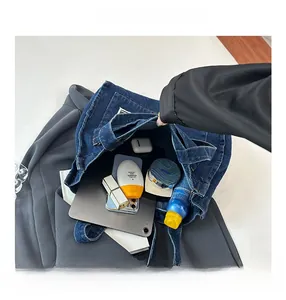 Detail view of large blue denim tote bag interior showing spacious storage for daily items