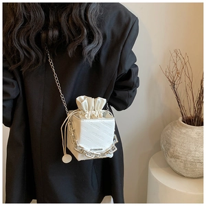Close-up of a white mini bucket bag with rich rabbit embossing and silver chain details
