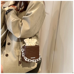 Detail of brown leather chain crossbody bag with club rabbit embossing and silver hardware